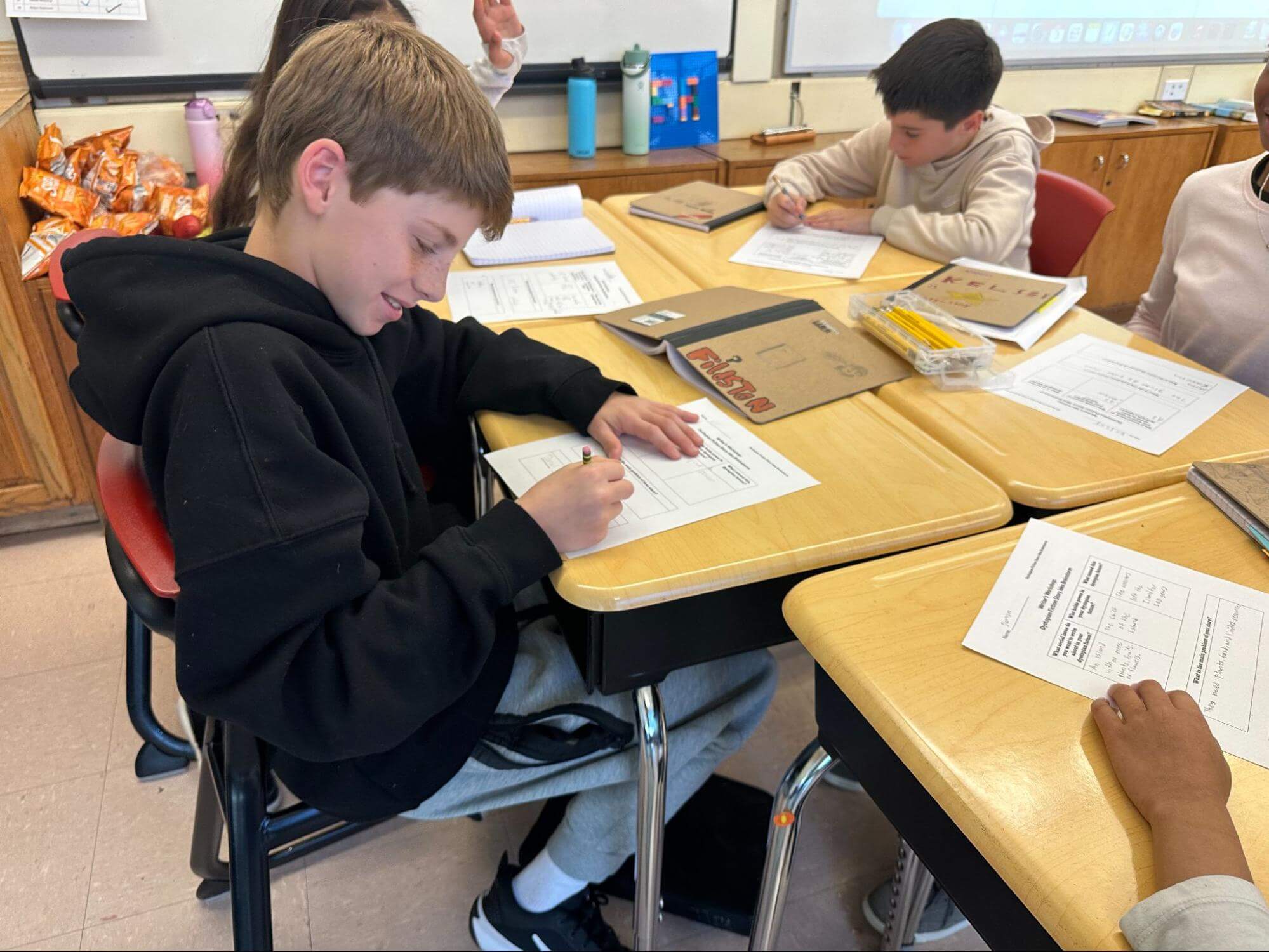 Students at Ethical Culture Fieldston School sit at a desk participating in a writing workshop.