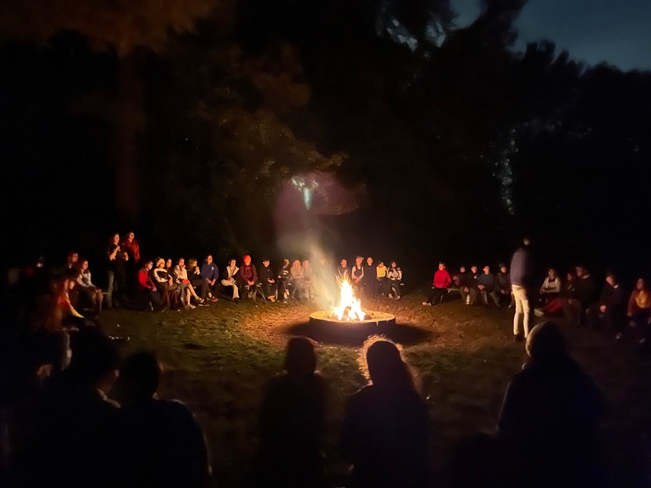 Ethical Culture students sit around fire at night at Nature's Classroom.