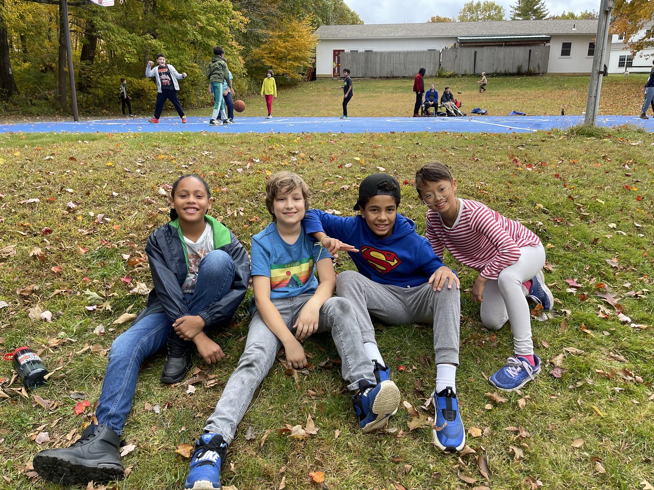 Ethical Culture 5th Graders sit in grass together at Nature's Classroom.