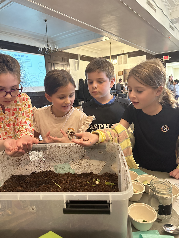 Students observe red wiggler worms at event.
