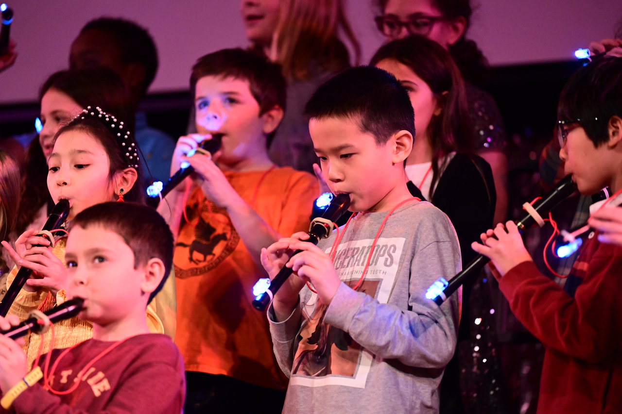 Ethical Culture student plays recorder at Holiday Assembly. 