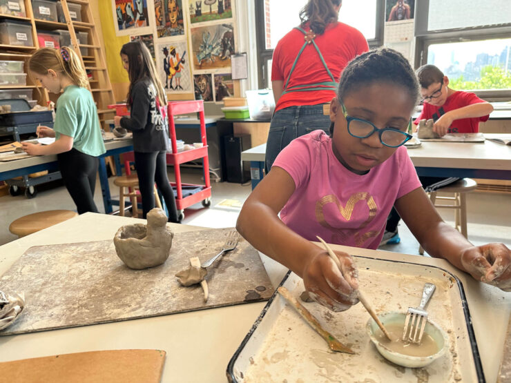 Ethical Culture student works to shape her clay in art classroom.