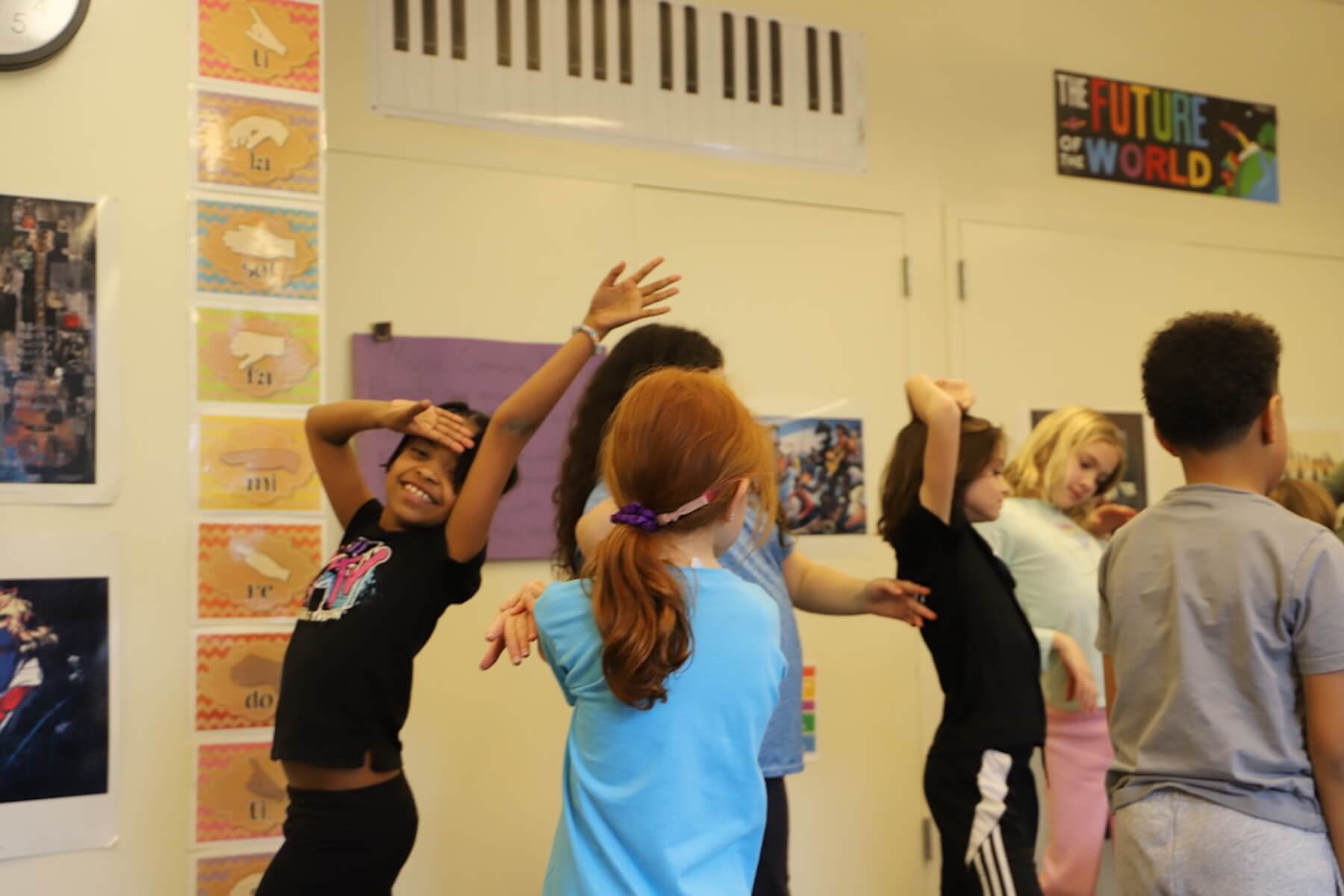 A group of Fieldston Lower 3rd Graders rehearse their dance moves for the musical. One student strikes a dramatic pose.