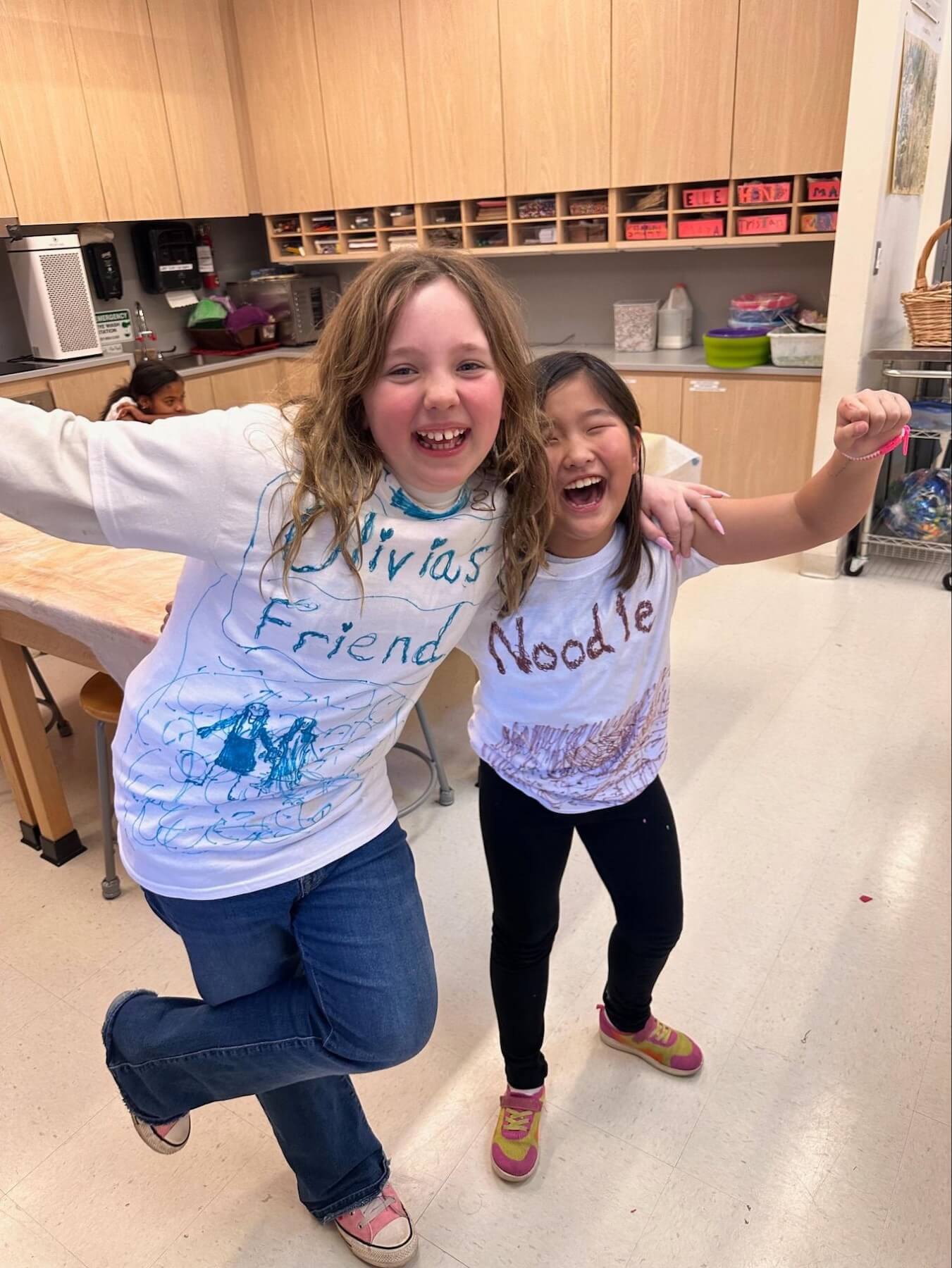 Two Fieldston Lower 3rd Graders smile proudly as they show off their self-designed costumes for the musical.