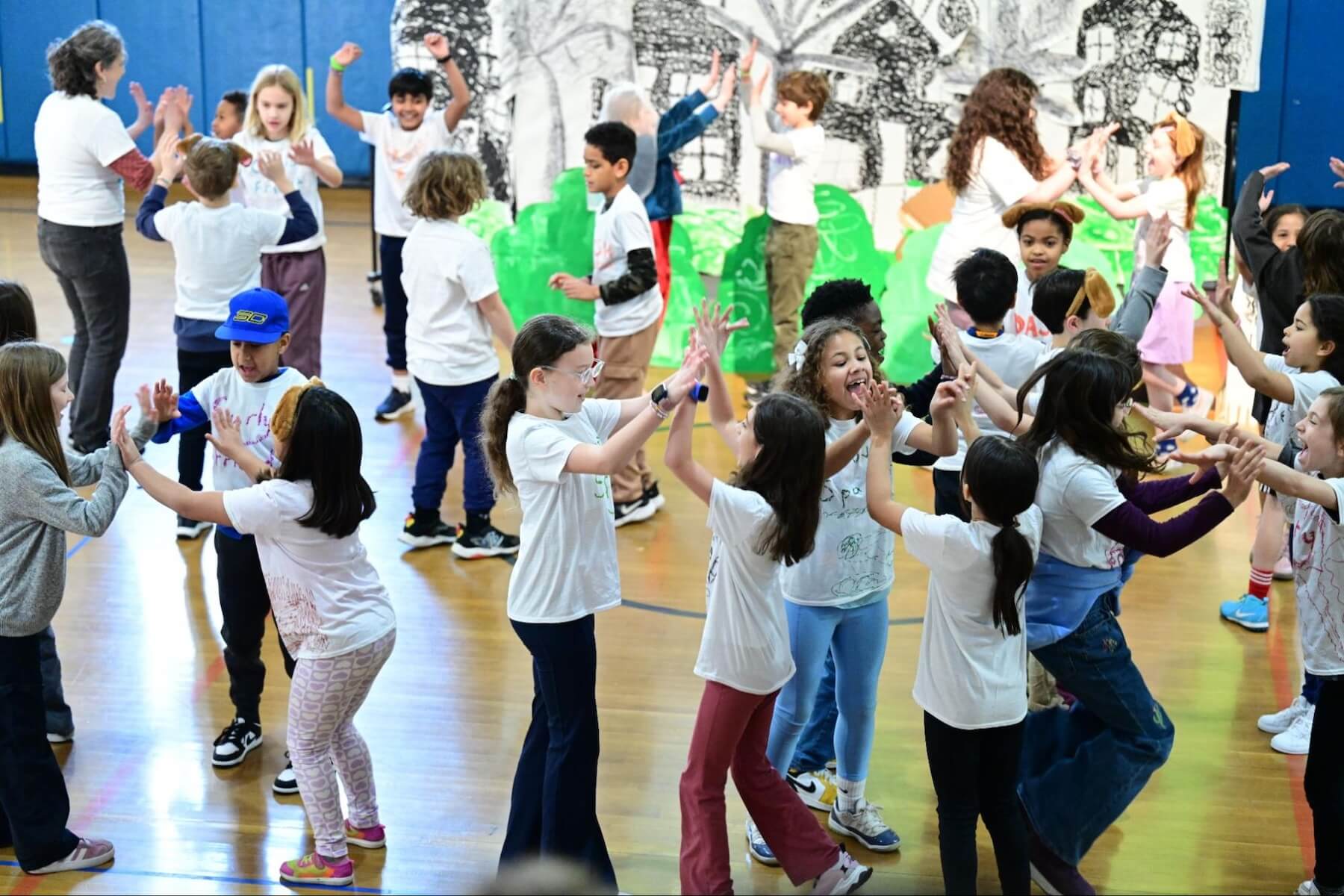 A crowd of Ethical Culture Fieldston School students dance joyously with each other as they perform during the 3rd Grade musical.