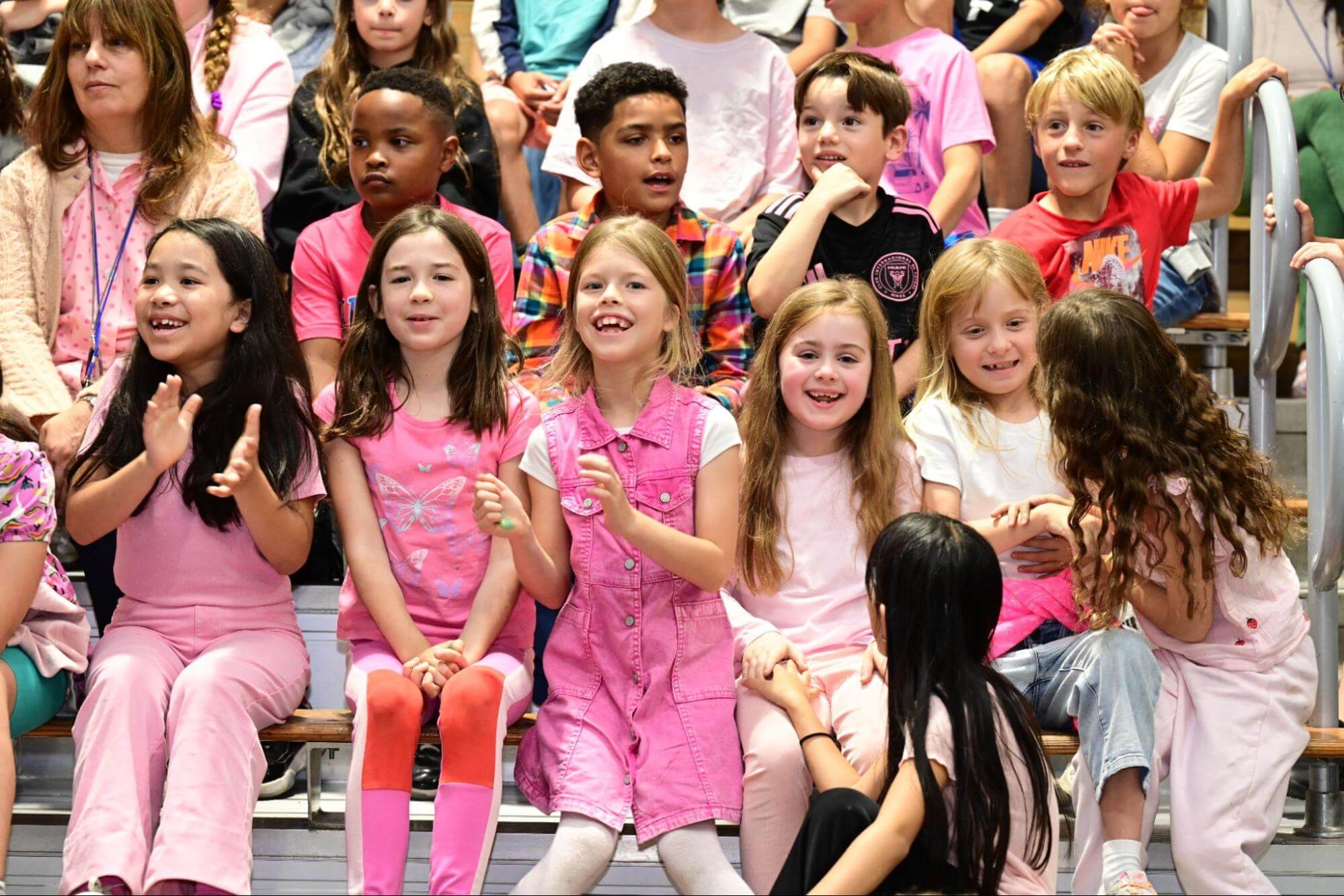 a group shot of Ethical Culture Fieldston School Fieldston Lower students cheering at an assembly.