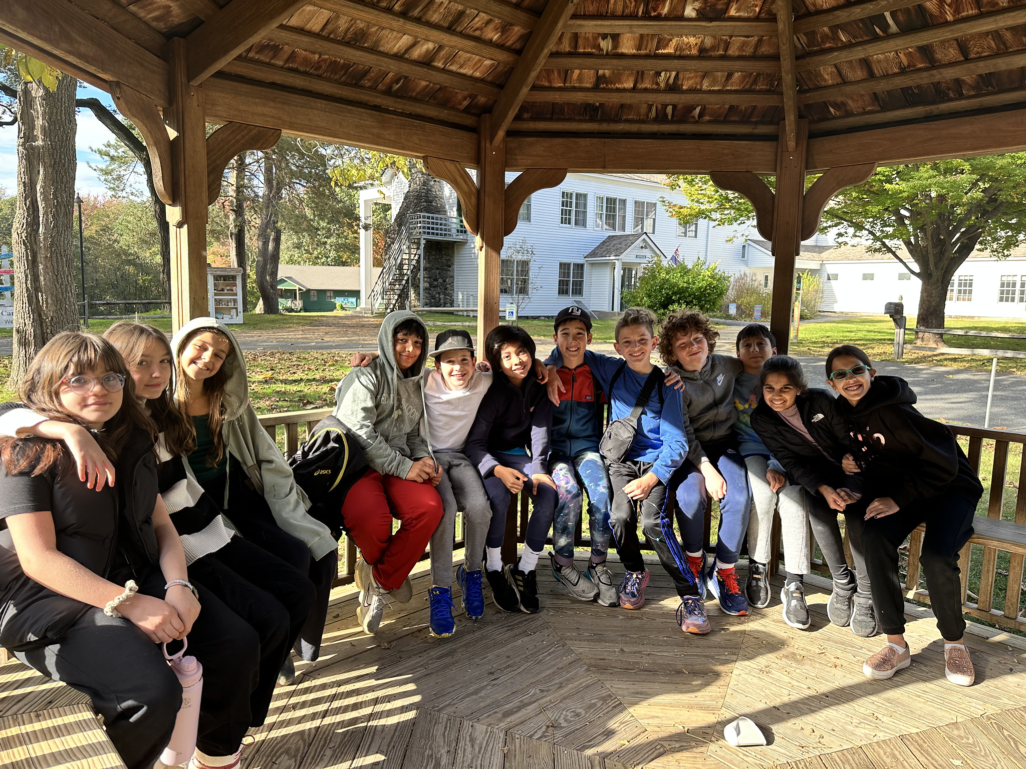 ECFS 5th Grade students smile together while sitting in a gazeebo.