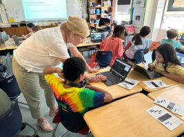 Mella assists Fieldston Lower student with his Google Earth project.