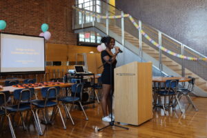 ECFS student speaks at podium at Bridge to Bridge year-end celebration in the Dining Hall.