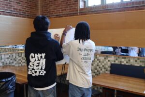 Fieldston Upper students sign poster for seniors at the Bridge to Bridge celebration.