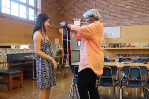 Bridge to Bridge faculty advisor Janet Pugh gives sash to Fieldston Upper senior student.