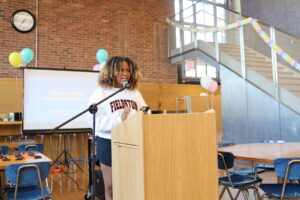 ECFS student speaks at podium at Bridge to Bridge year-end celebration in the Dining Hall.