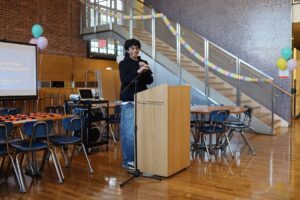 ECFS student speaks at podium at Bridge to Bridge year-end celebration in the Dining Hall.