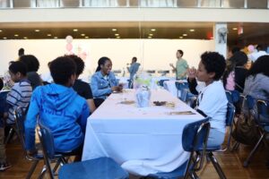 ECFS students smile and sit at table at Bridge to Bridge Celebration