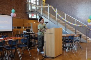 ECFS student speaks at podium at Bridge to Bridge year-end celebration in the Dining Hall.