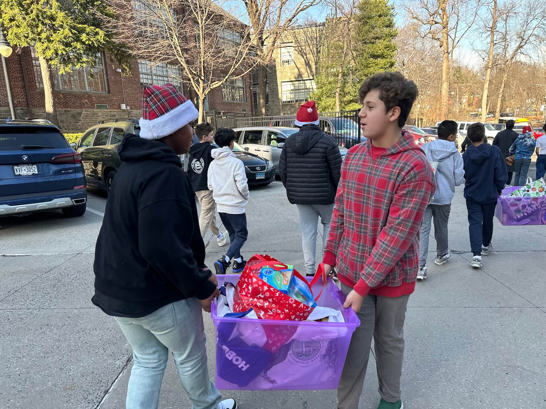 Two Ethical Culture Fieldston School 7th Grade boys carry a bag of donations