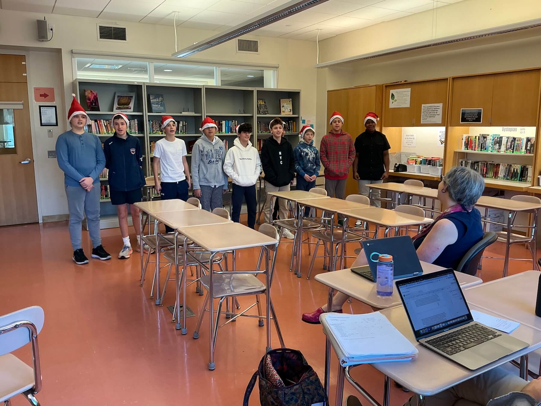 The members of Ethical Culture Fieldston School's 7th Grade Boys Chorus stand in a group singing.