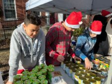 Three 7th Grade students at Ethical Culture Fieldston School sort donations of canned goods.