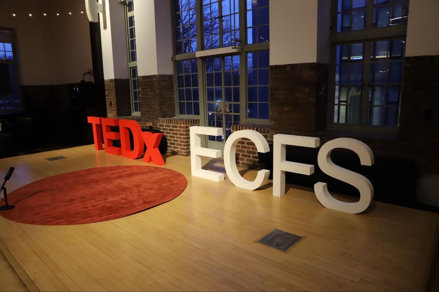 A sign that reads "TEDx ECFS" on stage at Ethical Culture Fieldston School.