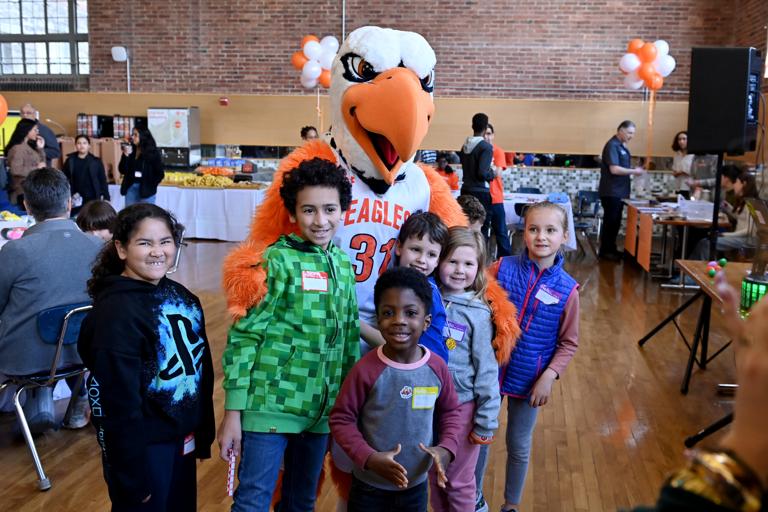 A group of elementary school aged kids pose for a picture with the ECFS Eagle mascot